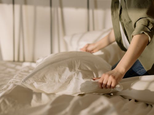 Person in White Dress Shirt Holding White Textile