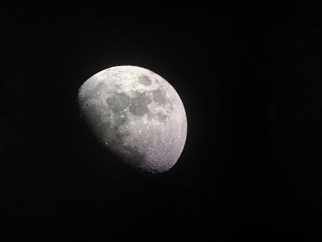 Stunning close-up of the half moon captured in a dark night sky, showcasing lunar craters and surface details.
