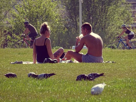 一对夫妇在阳光明媚的公园里，享受着大自然和骑自行车的人环绕的时光