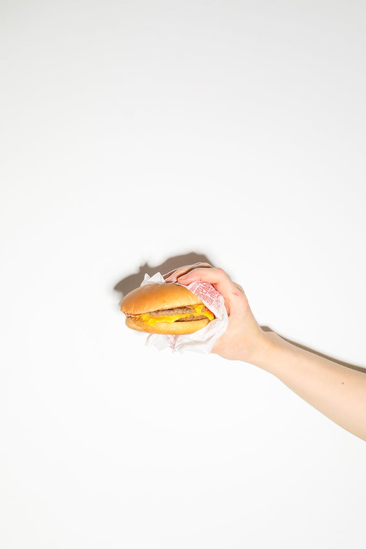 Person Holding A Cheeseburger