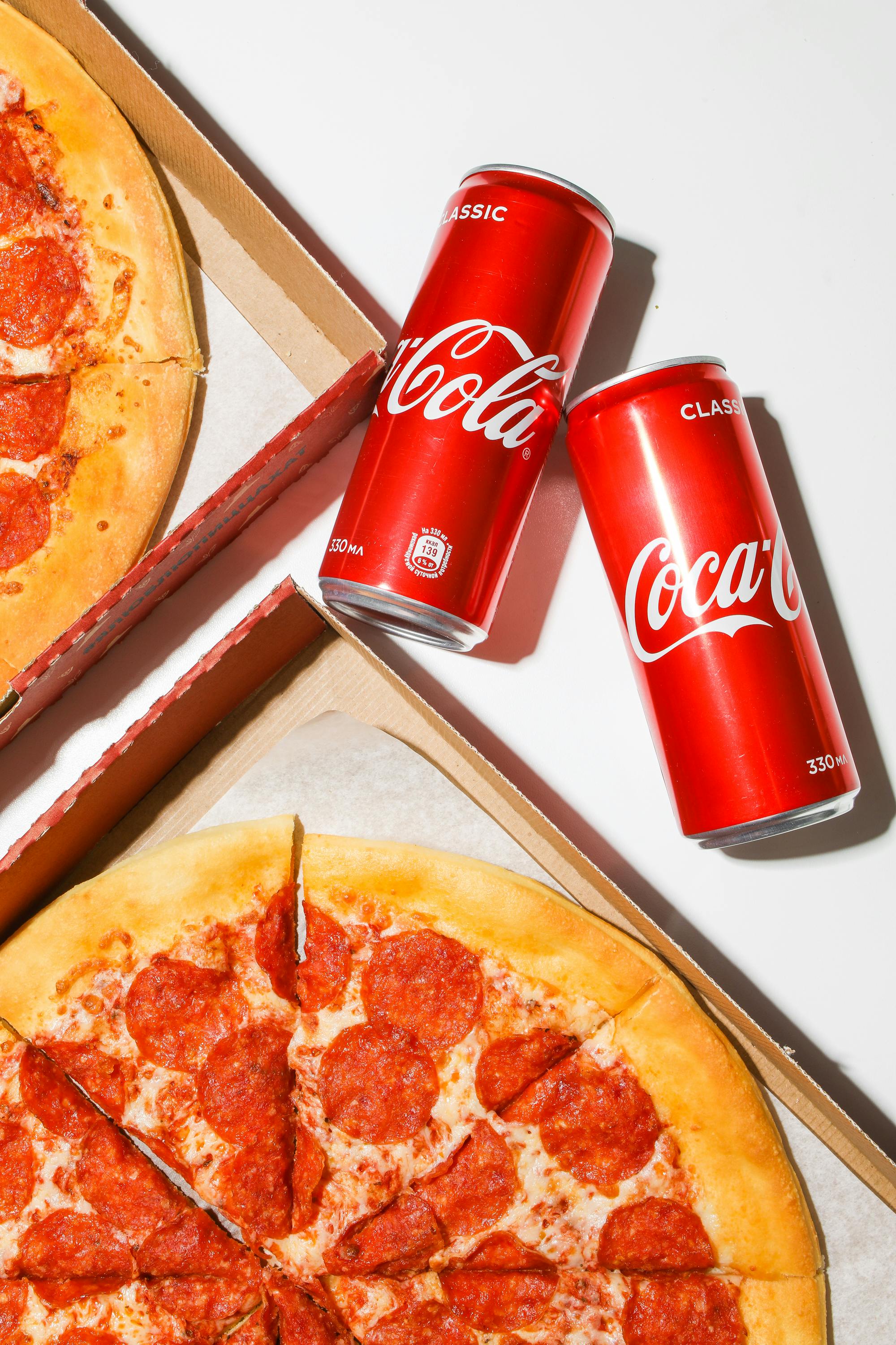 red coca cola cans beside pizza