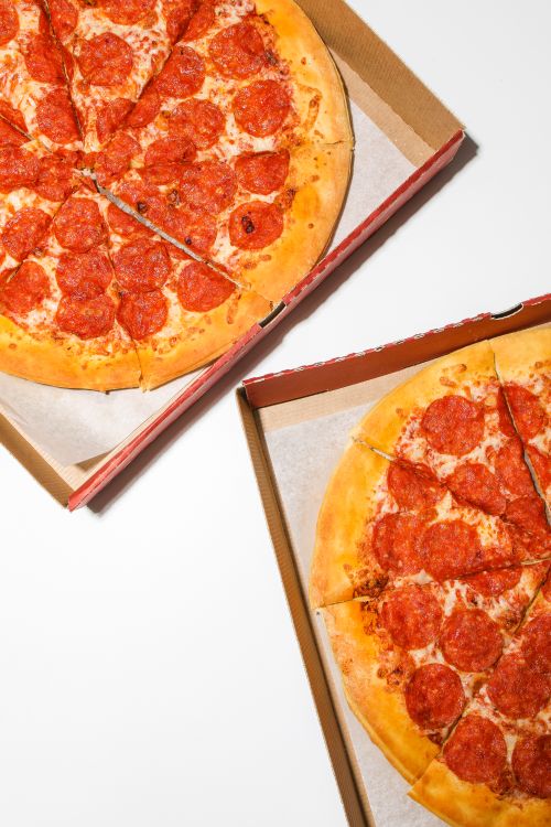 Free Top view of two pepperoni pizzas in cardboard boxes, ready to be served. Stock Photo