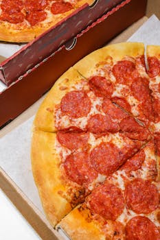 Mouthwatering pepperoni pizza in a cardboard box, ready to enjoy.