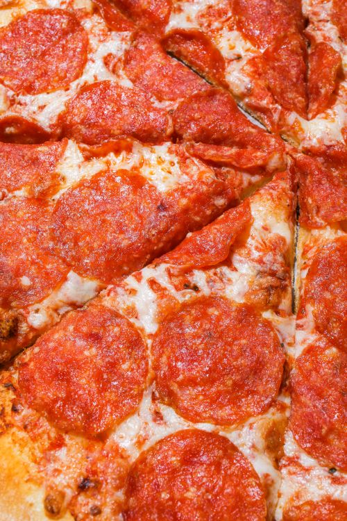 Free Close-up view of mouth-watering pepperoni pizza slices topped with melted mozzarella. Stock Photo