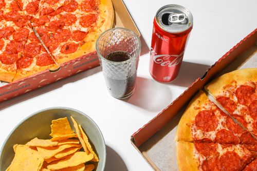 Free A tempting spread featuring pepperoni pizza, chips, and a refreshing soda. Stock Photo