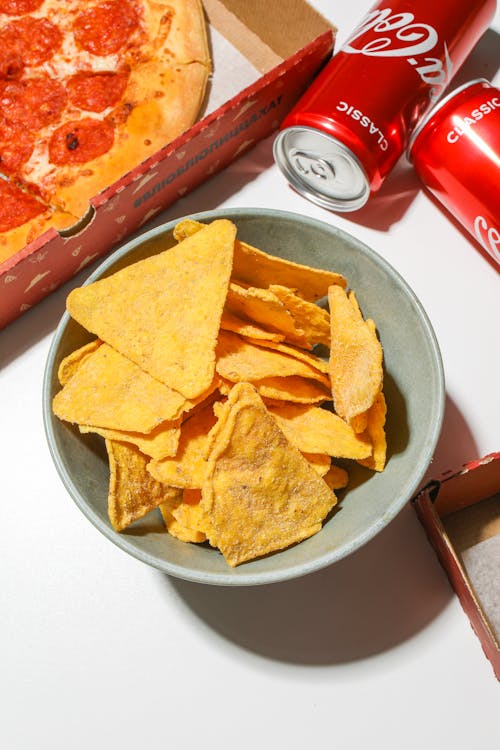 Free Chips in a Bowl Beside Pizza Box Stock Photo