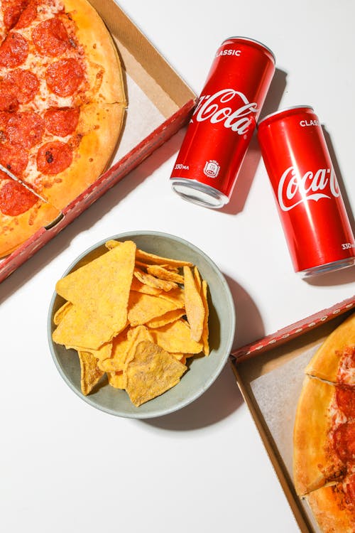 Red Coca Cola Cans Beside Food