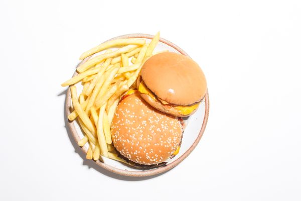Two cheeseburgers and french fries on a round plate — photo by Polina Tankilevitch on Pexels
