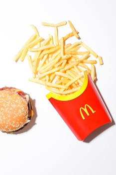 Top view of a delicious burger and McDonald's fries on a white backdrop, perfect for fast food themes.
