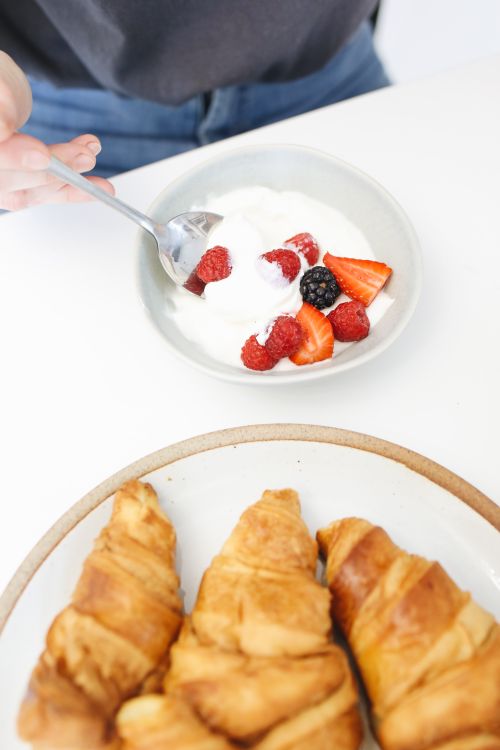 Free Top view of a breakfast with croissants and a bowl of yogurt with berries. Stock Photo