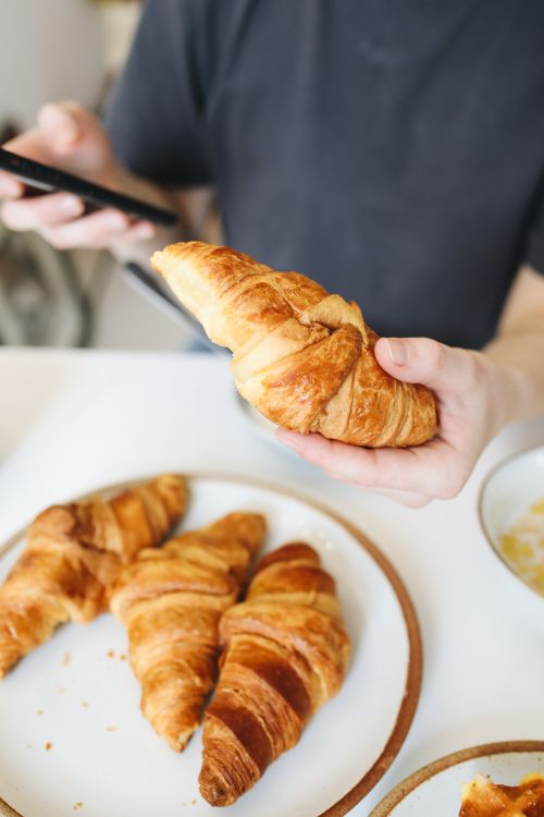 Free Freshly baked croissants being enjoyed for breakfast. Perfect morning treat. Stock Photo