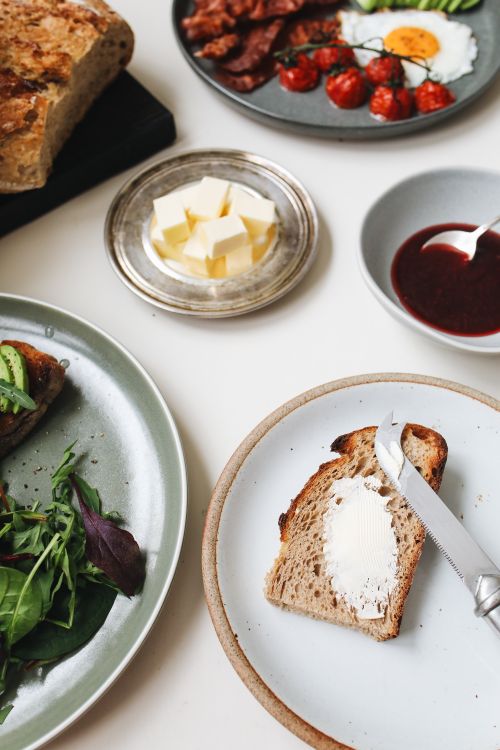 Free A visually appealing breakfast spread featuring buttered toast, fresh greens, eggs, and savory treats. Stock Photo