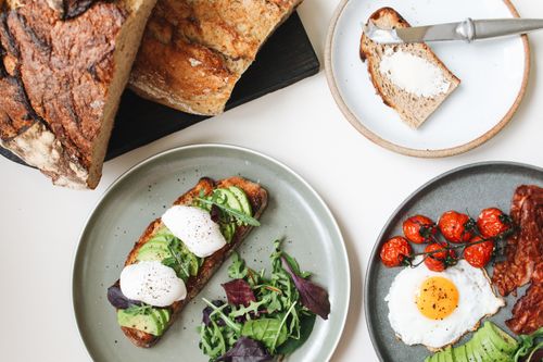 Free A vibrant breakfast table featuring avocado toast, eggs, and fresh tomatoes. Stock Photo