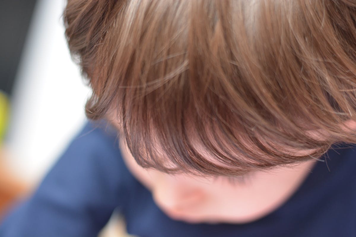 Person slicing a piece of chocolate cake at a table with tea
