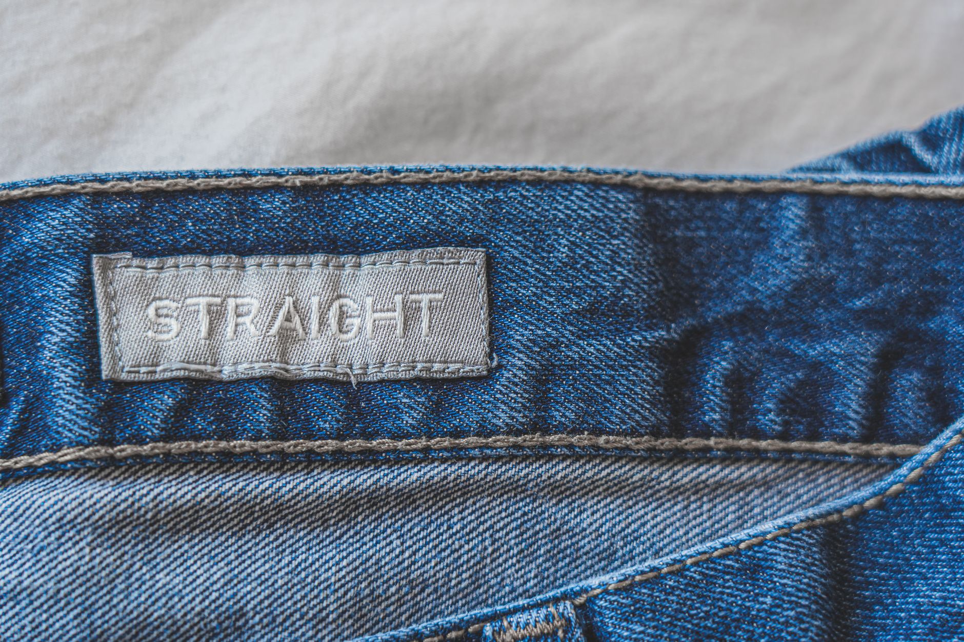 close-up of trouser waistband interior showing stitched facing construction versus fused construction SOURCE: Pexels