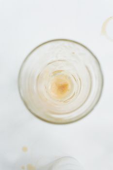 一只空玻璃杯的俯视图，杯口留有咖啡残渣，风格极简