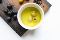 油中绿橄榄、黑橄榄与砧板上胡椒的俯视画面