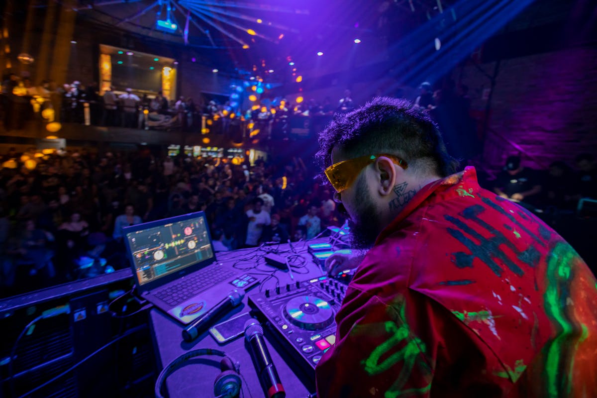 A pot of simmering bean and vegetable stew being stirred with a wooden spoon