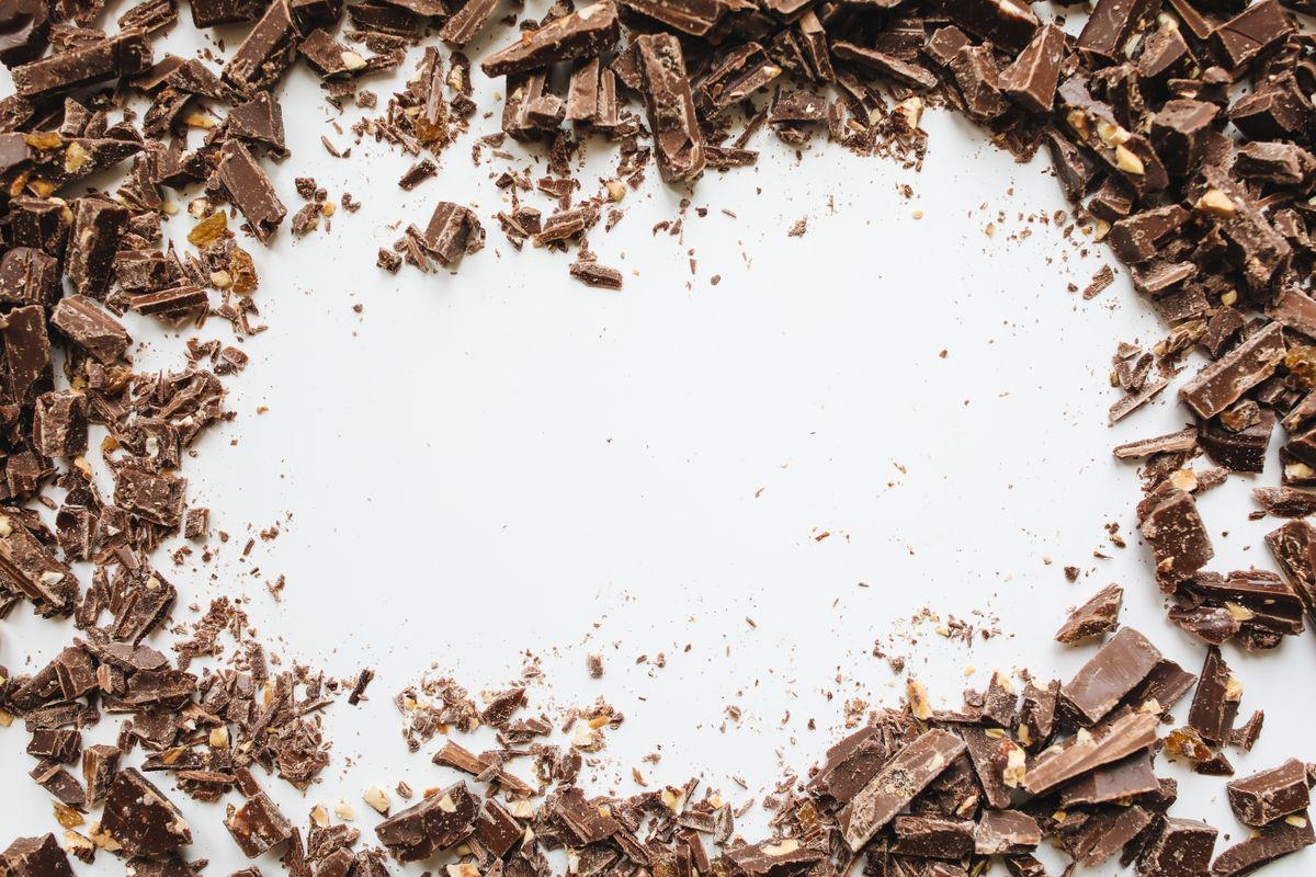 Scattered chocolate chunks on a white surface creating an indulgent food texture.