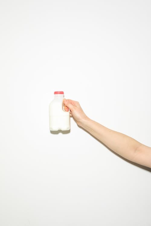Free Person Holding White Plastic Bottle Of Milk Stock Photo