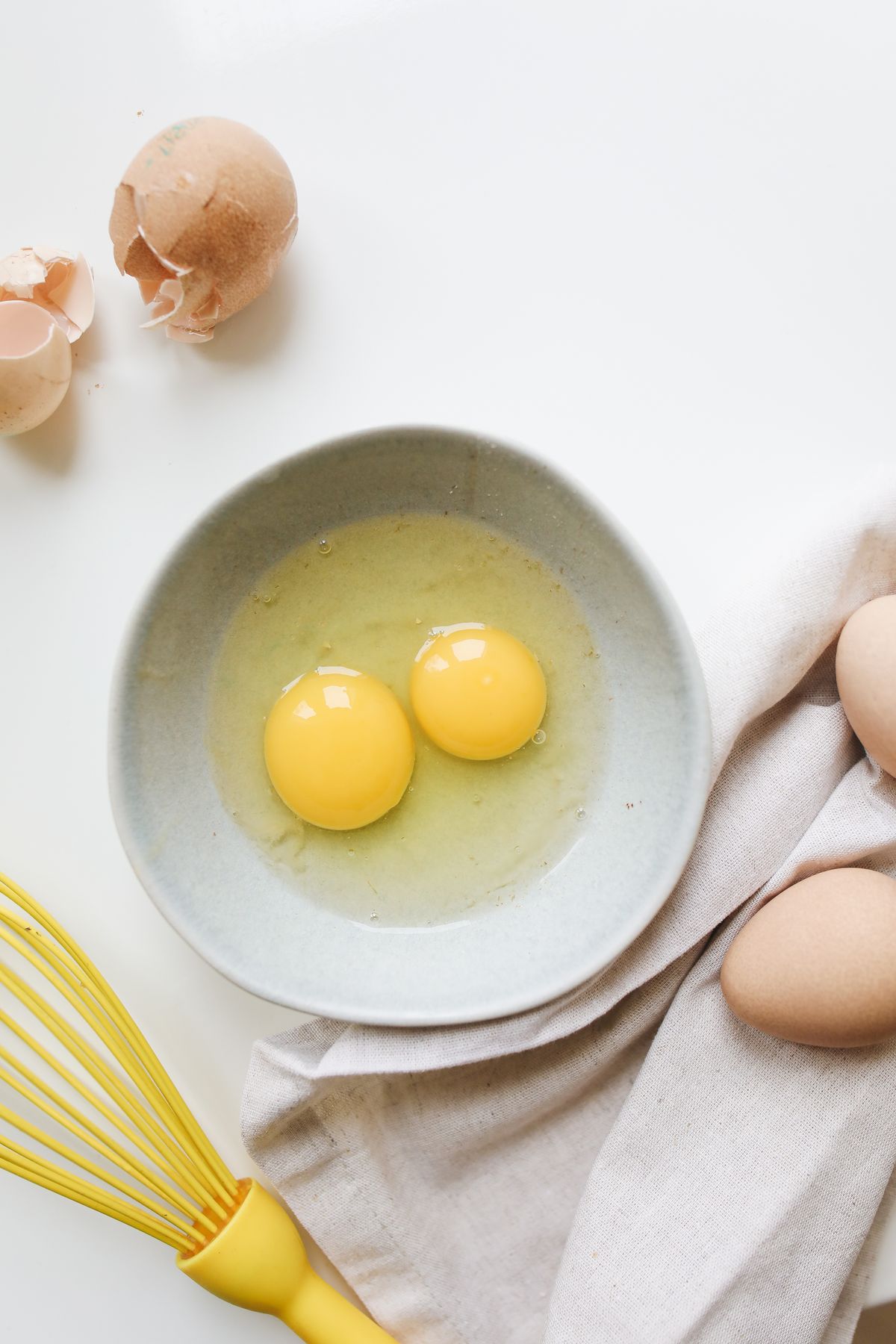 Egg yolks and a whisk in a bowl