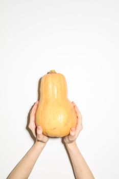 Hands holding a butternut squash against a white background, highlighting nutrition.
