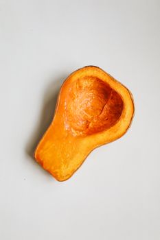 南瓜被切成两半放在白色表面上，露出充满活力的橙色内瓤