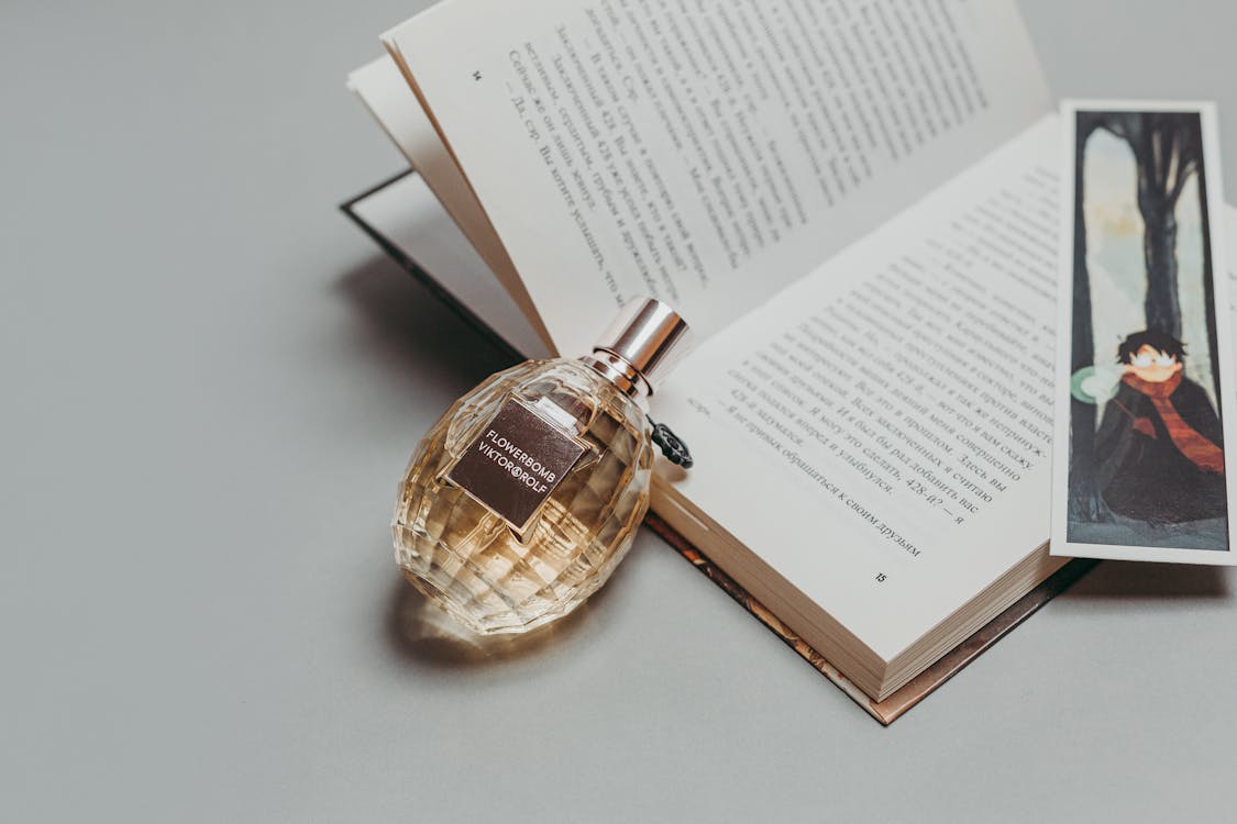 Photo Of Perfume Laying On Book 