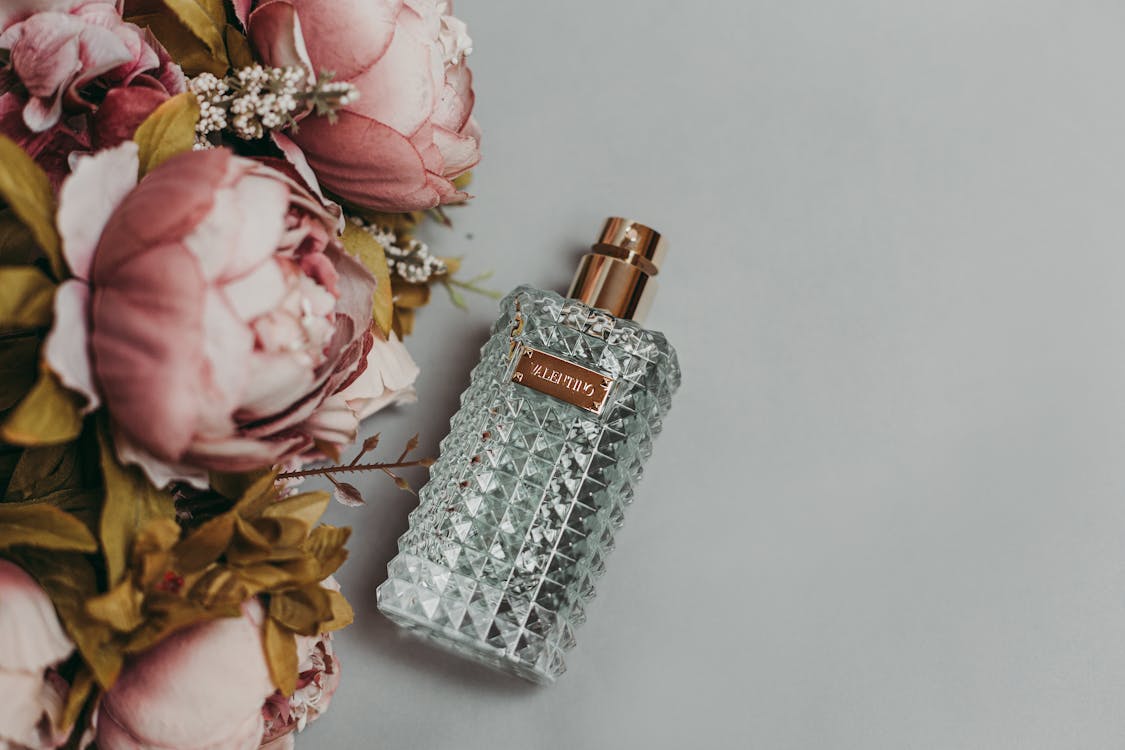 Photo Of Perfume Bottle Beside Artificial Flowers