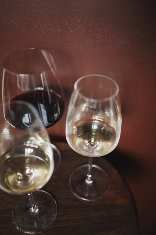 Clear Wine Glasses on Brown Wooden Table