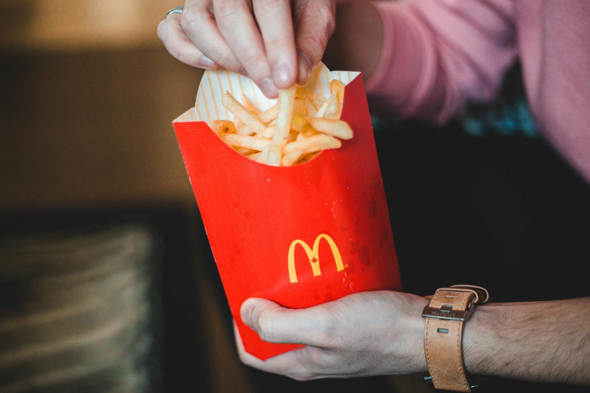 A person enjoying McDonald's fries, showcasing fast food and lifestyle themes.