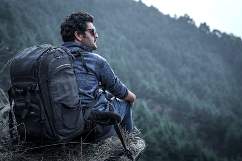 Photo Of Man Sitting On Cliff Edge