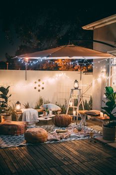 迷人的户外庭院在夜晚呈现出舒适座位与温暖灯光交织的场景