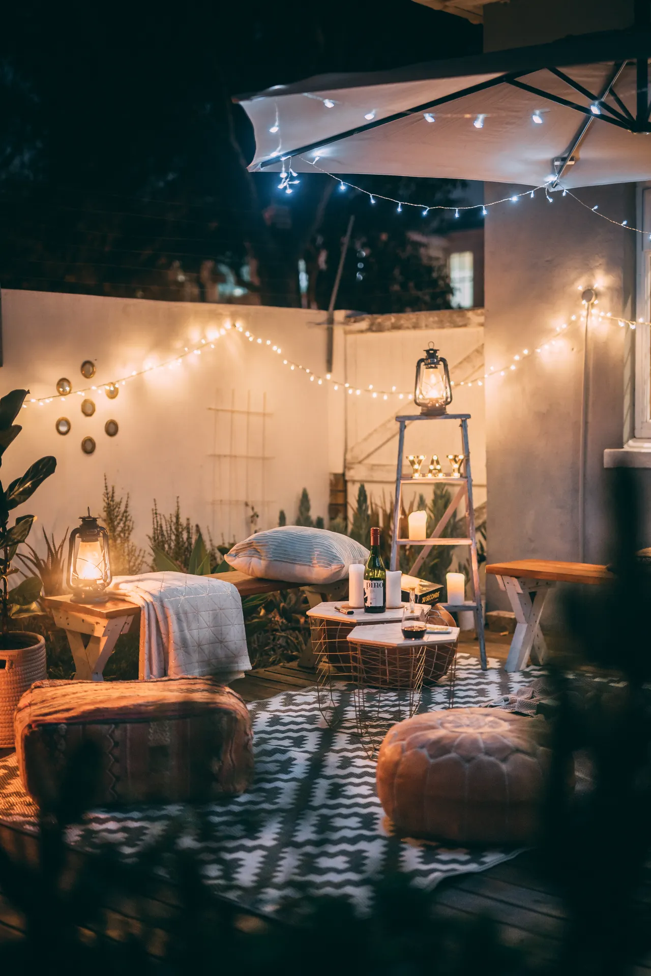 lanterns-candles-balcony-night Warmly lit outdoor patio at night with lanterns, seating, and decorative lights