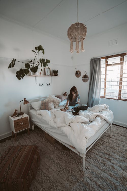 Photo Of Woman Sitting On Bed