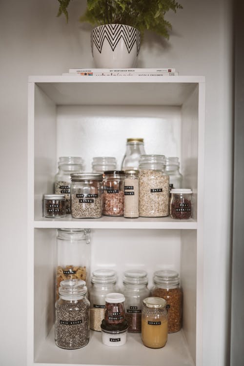 Clear Glass Jars on White Wooden Shelf