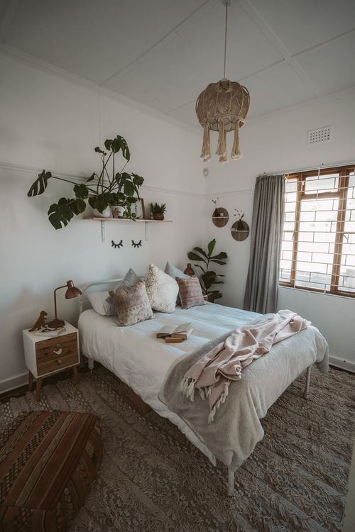 Free A serene bedroom with natural decor elements, soft lighting, and indoor plants. Stock Photo