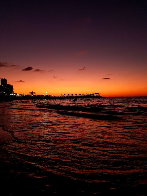 Sunset sky over waving sea and pier