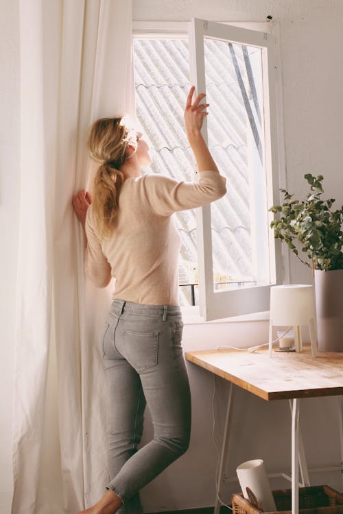 Frau, Die Aus Einem Fenster Schaut