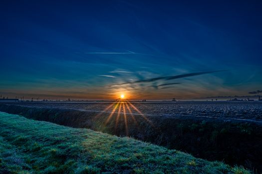 A stunning sunset over a tranquil open field, capturing the colors of the golden hour.