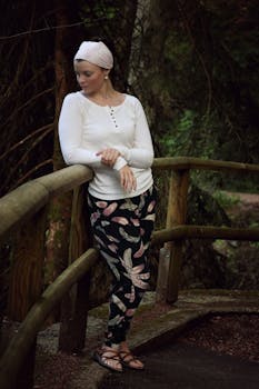 宁静的森林公园里，一名妇女靠在乡村木栏杆上沉思