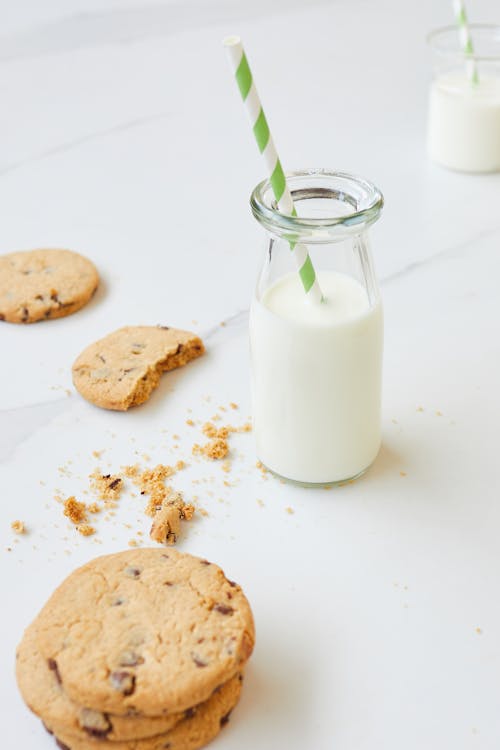 Milk in Clear Glass Jar With Green Straw