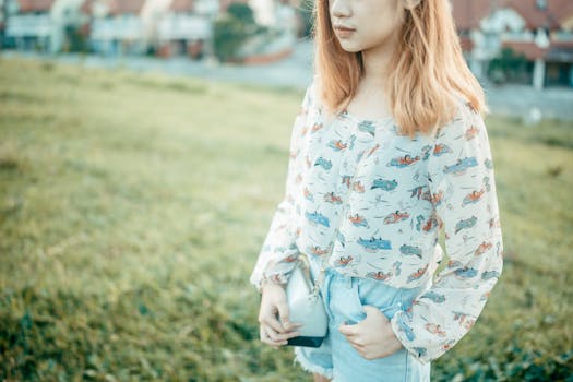 Young woman with blonde hair in a patterned blouse standing outdoors on a sunny day in Cavite City.