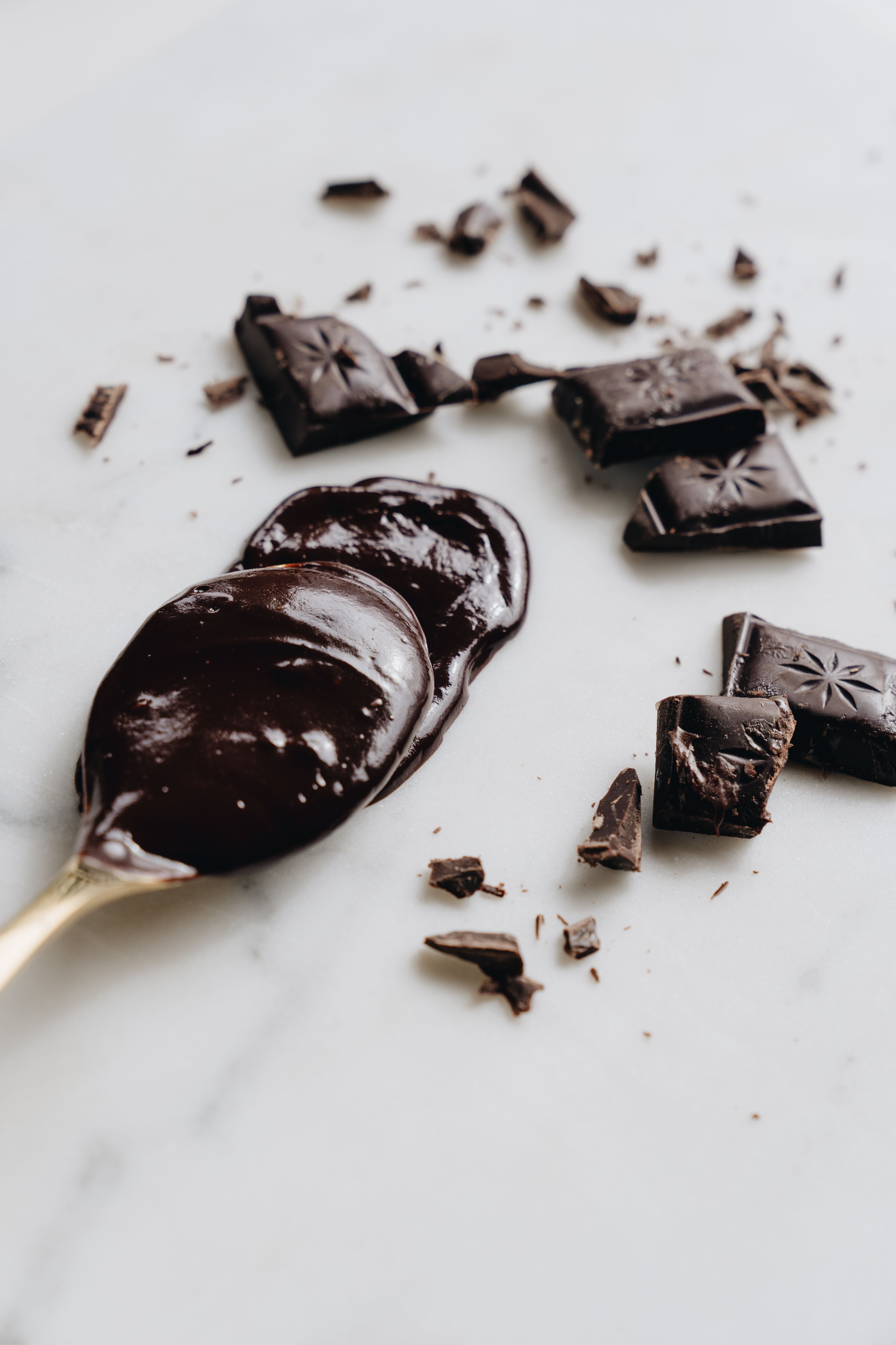 Rich dark chocolate bars and luxurious melted chocolate on a spoon.