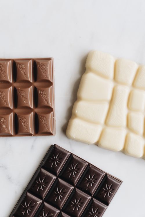 Free Three types of chocolate bars - milk, white, and dark - arranged on a white background. Stock Photo