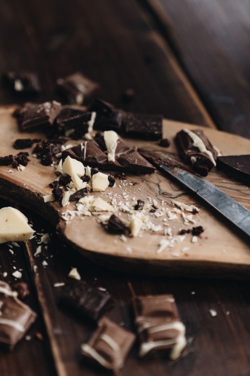 Free A close-up view of chopped chocolate pieces on a wooden board, creating a rustic feel. Stock Photo