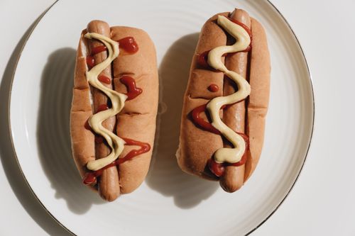 Free Two hot dogs on a plate topped with ketchup and mustard, ready to eat. Stock Photo