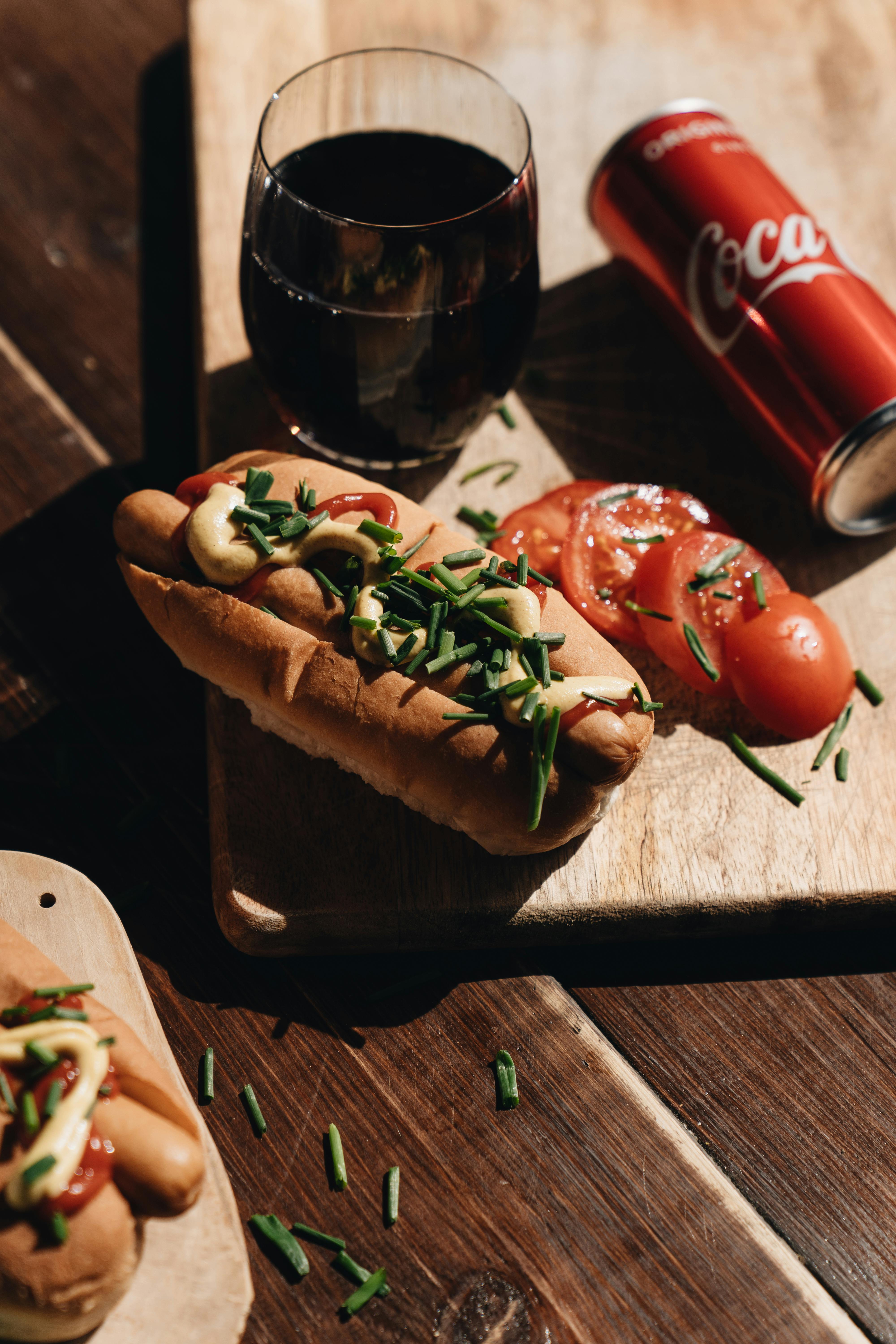 hot dogs on wooden board and coca cola