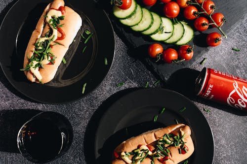 Hot Dog and Vegetables on Black Ceramic Plate