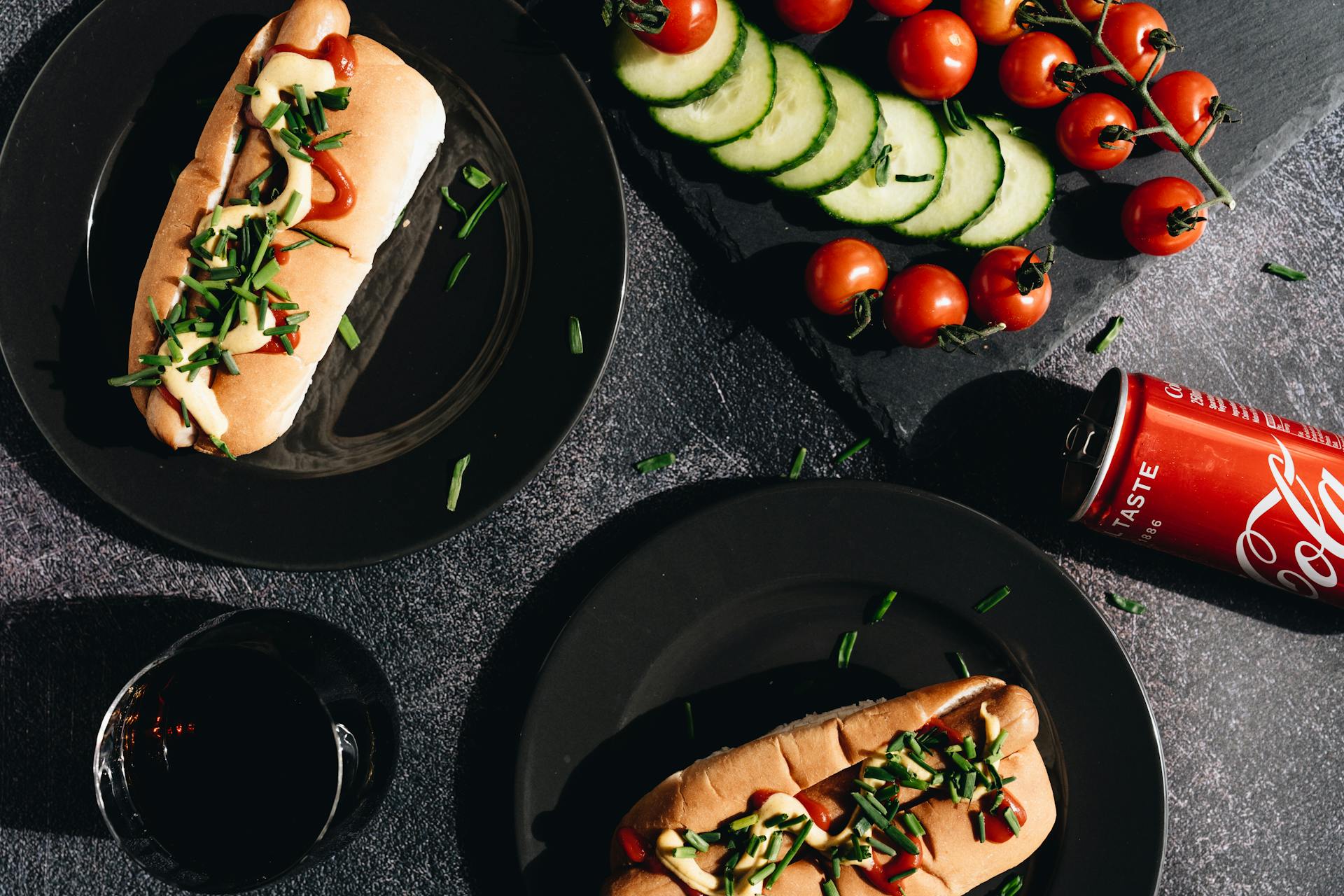 Hot Dog and Vegetables on Black Ceramic Plate